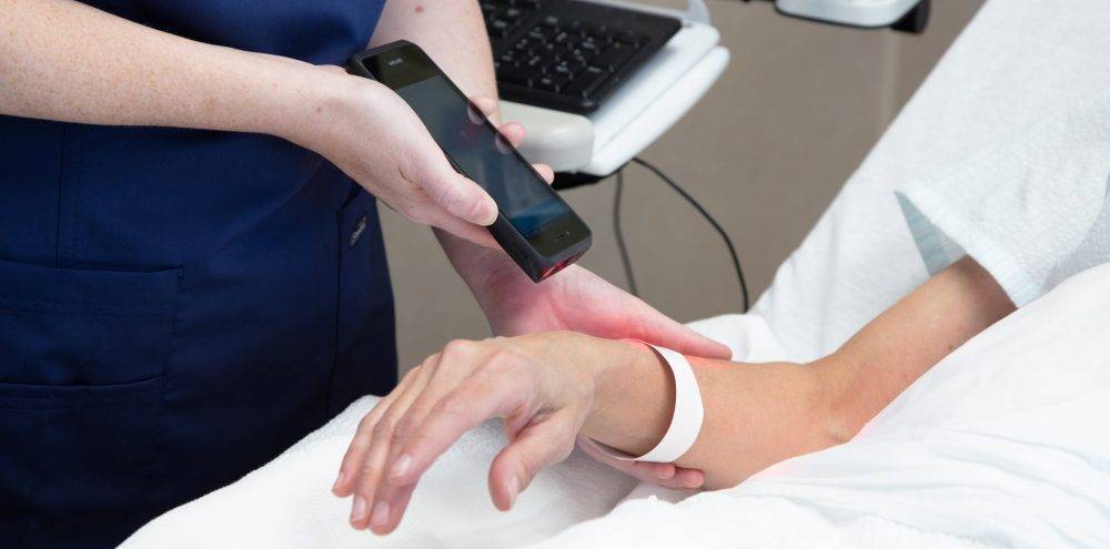 Healthcare worker using Spectralink device to scan patient wrist band