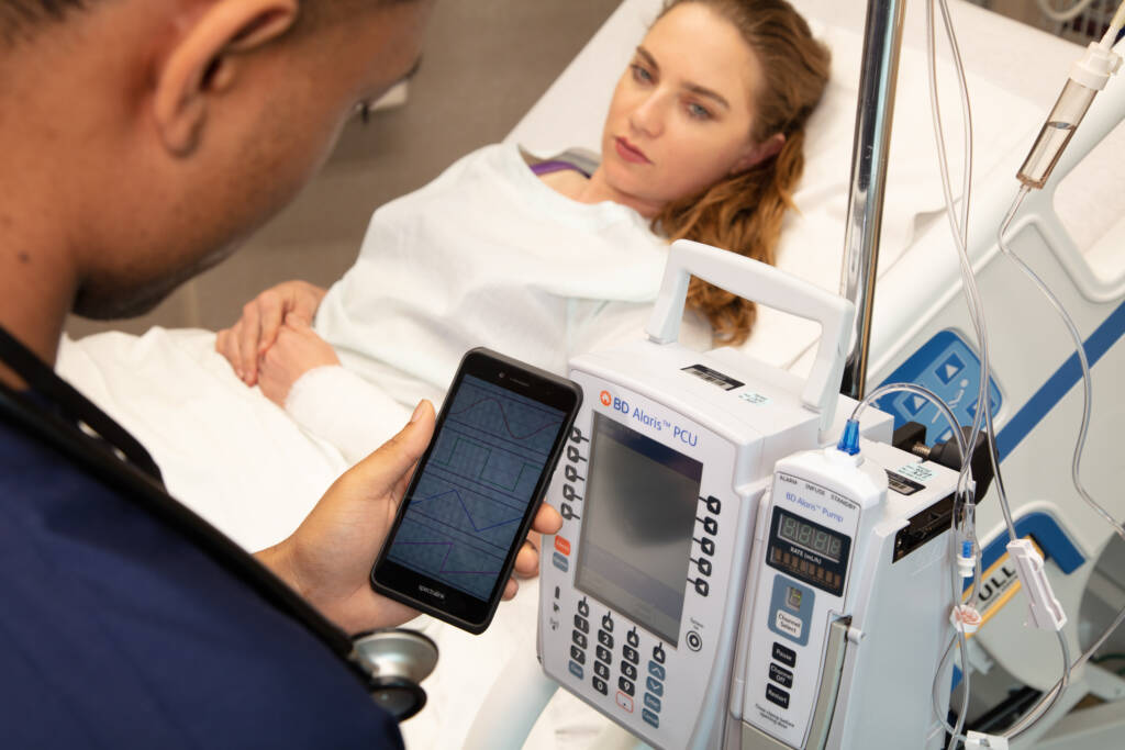healthcare worker using SpectraLink phone to monitor patient condition